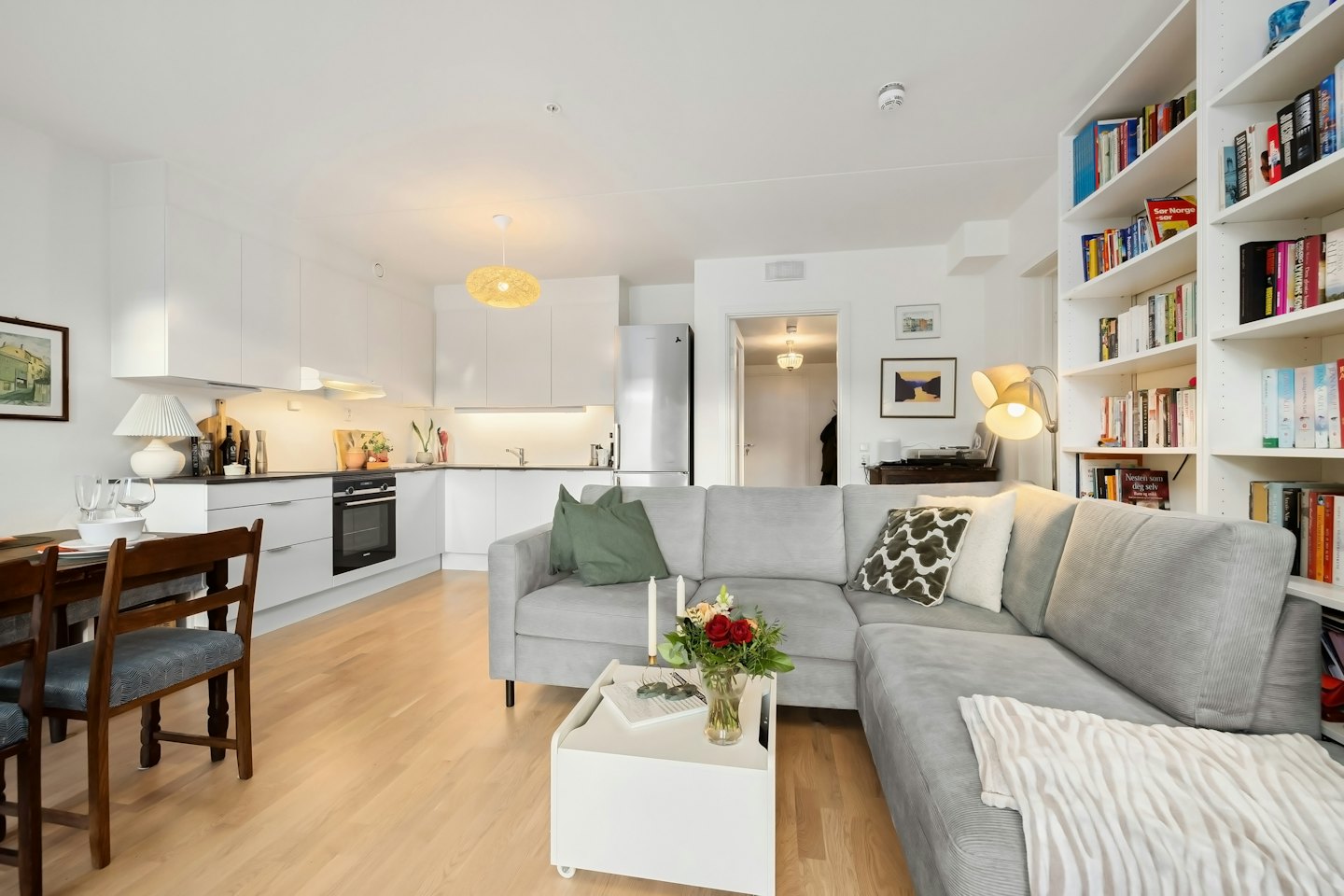 Open plan apartment featuring a grey sofa and modern kitchen.